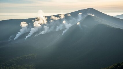 Multiple plumes of smoke rise from the forested slopes of mountains under a hazy sky, illuminated by soft sunlight.