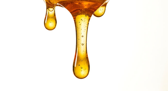 Golden honey drizzling from wooden honey dipper on white background