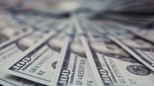 Close-up view of US dollar banknotes fanned out in a circular arrangement, showcasing intricate details of the currency and emphasizing the texture and design elements
