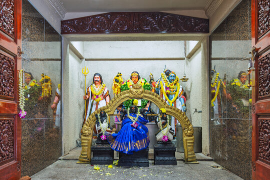 Vibrant Hindu deity statues, including goddess Mariamman, adorned with garlands and ornate carvings inside Sri Maha Mariamman Temple, Kuala Lumpur, Malaysia