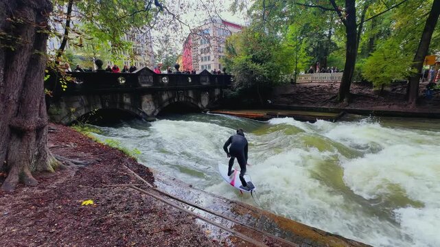 Autumn Fall surfers River Surfing morning Eisbachwelle Eisbach Isar River Munich Germany Englischer Garten artificial man made standing wave tourist attraction action sports stunts air reverse drop