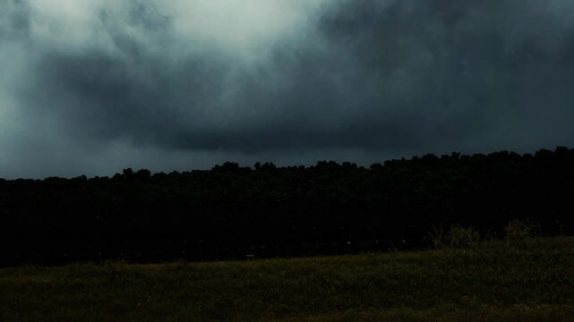 Heavy dark clouds are covering the sky, creating a dense, opaque layer of fog and mist, transitioning from light grey at the top to deep blue grey at the bottom