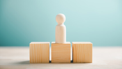 White wooden figure standing on a block, two other blocks on either side. Blue background.