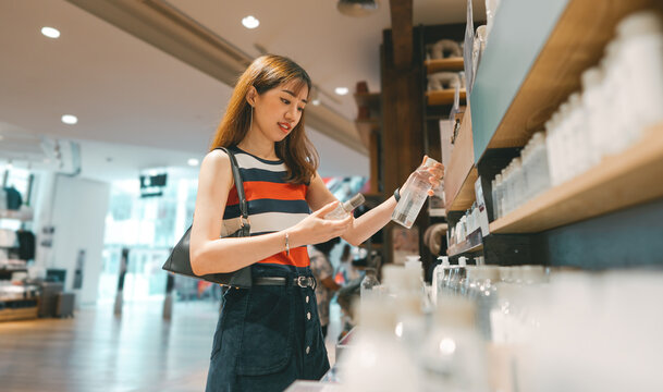  Asian woman shopping facial skin care in shoping mall customer choosing beauty product in retail sotre
