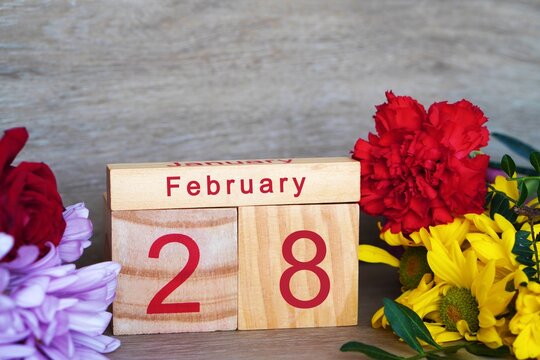 February 28th. Wooden calendar with fresh flowers. Copy space.