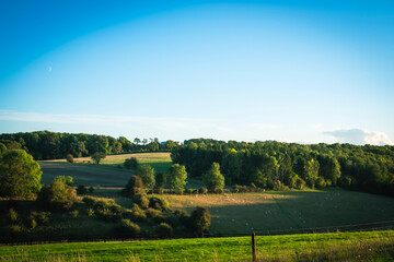 Beautiful rural sunset landscape in the green fields meadows in the Cotswolds, England