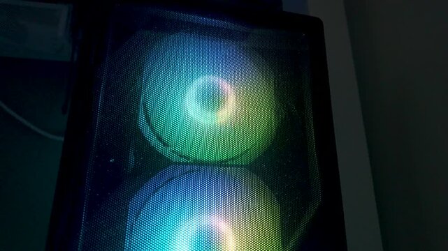 Colorful RGB cooling fans spinning inside computer case glowing with vibrant LED lights