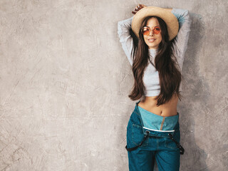 Portrait of Young beautiful woman looking at camera. Trendy female in casual summer overalls...