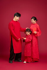 Young asian family interaction in red outfits, focused on emotional connection rather than pose, designed for cultural holiday themes