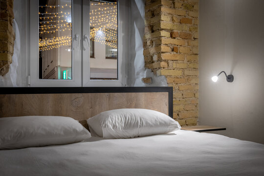Double bed in a private loft hostel room with night city view