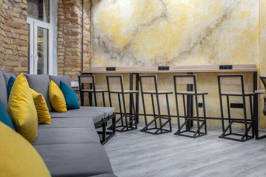 Hostel common area with modern lounge seating and bar counter at night