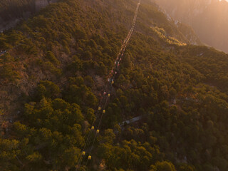 Obraz premium View of a long line of cable cars ascending a forested mountain in Lushan Mountain, Jiangxi, China