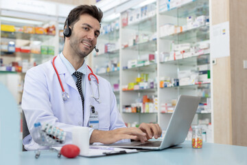 Male healthcare professional using laptop and headset while smiling. Confident pharmacist or doctor...