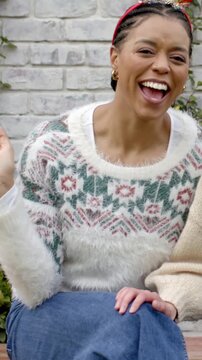Vertical video: Reacting to pal touching knee, laughing woman turning on patio bench, fuzzy sweater