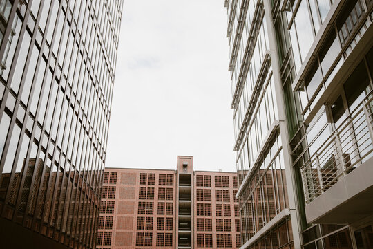 Urban modern architecture building facade of glass office blocks around a quiet courtyard with reflection and wide sky for abstract copyspace
