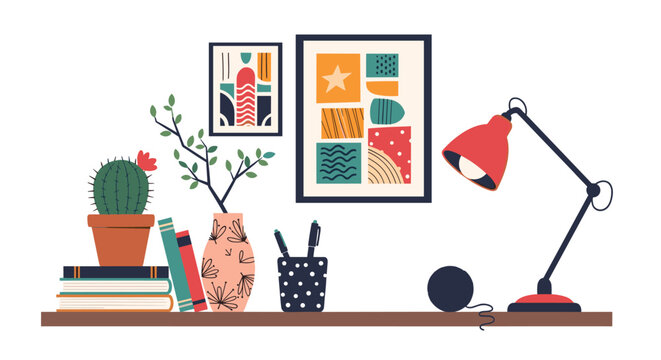 Still life of an organized home office workspace features books and a red desk lamp on a wooden shelf against creative framed wall art prints.