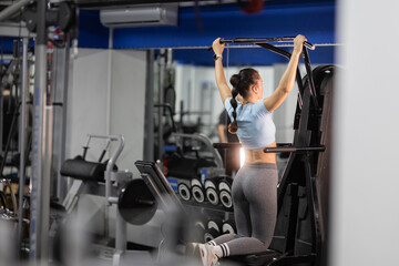Fototapeta premium Woman building upper body strength doing pull-ups