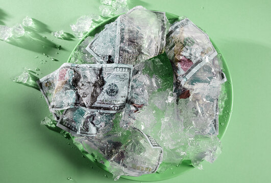 Dollar bills encased in melting jelly cake as a metaphor for inflation