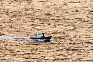 Obraz premium 日の出の海。 ぐんじ山展望台から見る美しい伊豆諸島の海。 沖には新島や神津島が見える。 白い石灰岩の崖、白ママ断崖の沖には無人島の早島。 乗用車を乗せた大型貨物船や漁船も見える。 式根島は東京都心から南へ160km。 外周12kmの小さな有人島。 温かい黒潮が当たり水温と水質が高い。 また、リアス式の入り組んだ入り江が多く、海水浴や釣りが盛ん。 温泉島としても有名。海際に多くの無料露天風呂がある。