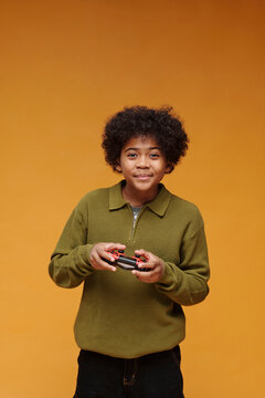 Smiling gamer holding joystick playing video game indoors