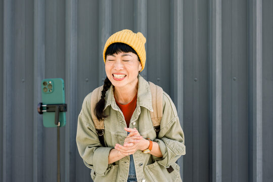 Smiling woman making a video blog outdoors with mobile phone