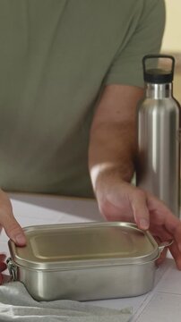 Closing a Tupperware container with healthy food in a modern kitchen