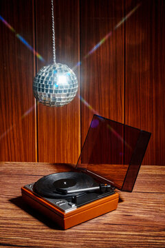 Vintage record player and disco ball in retro wooden interior
