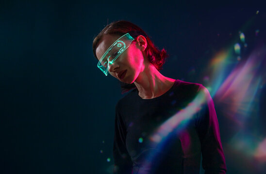 Person wearing glowing virtual reality glasses in neon indoor setting
