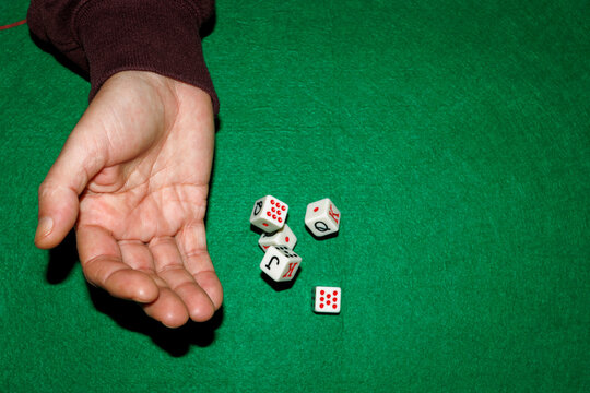 Hand throwing dice on green mat during a board game closeup