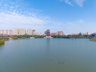 Obraz premium Aerial view of a lake with buildings and a pagoda in Tianmen City, Hubei Province
