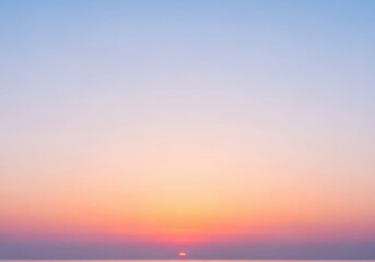 Fototapeta premium Soft sunrise emerging above a calm horizon, gentle pastel bands of peach and blue blending together as night slowly lifts into a peaceful new day