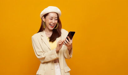 Mobile app usage concept with Asian woman smiling while using smartphone to represent digital communication online interaction social media engagement modern lifestyle technology.