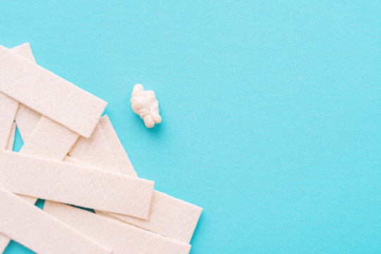 Chewing gum sticks scattered on turquoise background, copy space. High quality photo