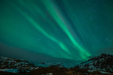 Breathtaking Northern Lights dancing above the iconic Kirkjufell mountain in Iceland. A magical...
