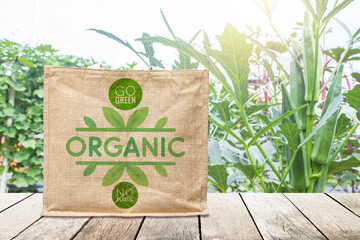 Organic logo on jute bag over Okra garden background, organic farming product concept