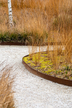 Modern sustainable landscape garden design with natural plants gravel pathway texture and curves creating calm city green outdoor space