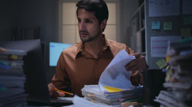Paperwork and overworked document work show a clerk in accounting and law report research, searching files on a laptop in an office shaped by bureaucracy.