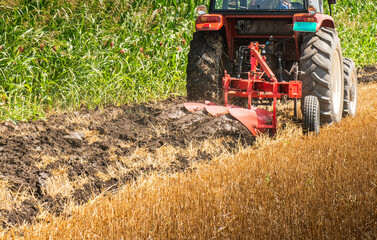 Obraz premium Agricultural works at farmlands, agriculture tractor-closeup