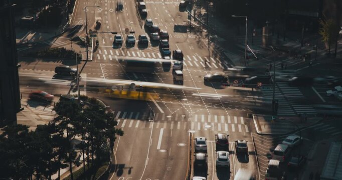 A bustling city intersection captures vehicles moving and pedestrians navigating crosswalks, illustrating the rhythm of urban life and continuous motion. Time-lapse, Seoul, South Korea