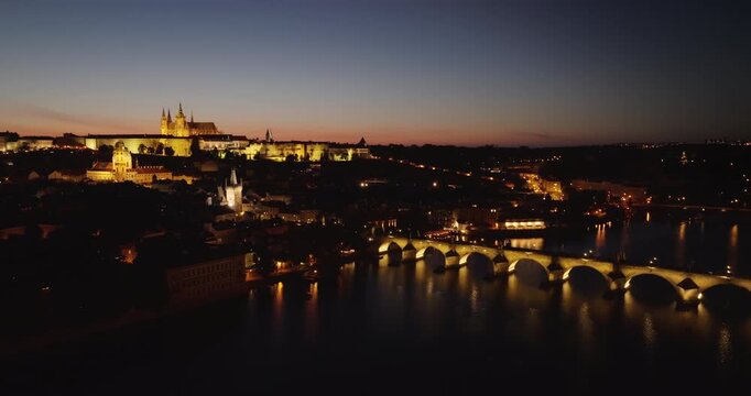 Night aerial of Prague with Charles Bridge, Vltava River and illuminated Prague Castle.