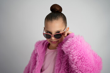 Stylish Young Girl in Bright Pink Faux Fur Jacket and Sunglasses