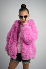 Stylish Young Girl in Bright Pink Faux Fur Jacket and Sunglasses