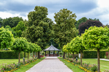 Fototapeta premium The Botanical Garden of Augsburg in Germany with garden pathes and topiary boxwood bushes on green meadows