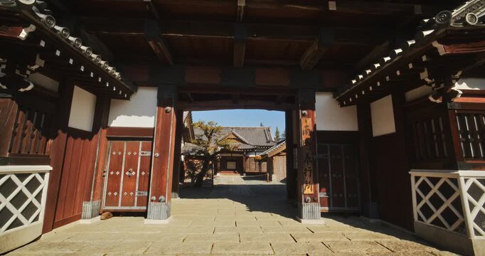 Smooth steady cam shot through majestic, old Japanese building into courtyard