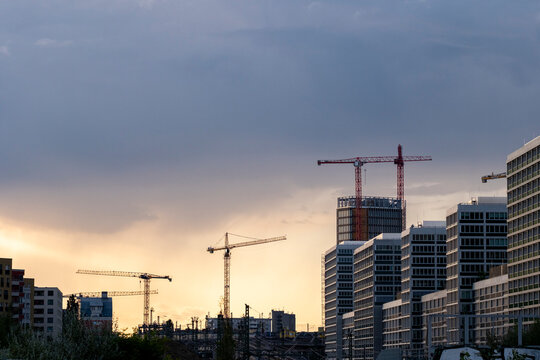 Sunset clouds over Berlin city skyline with construction cranes and urban architecture showing fast development across modern districts