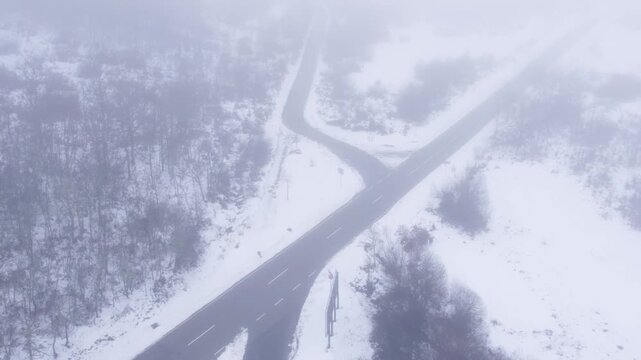 Aerial view of road fork in snowy forest with thick fog The Concept of Decision Making