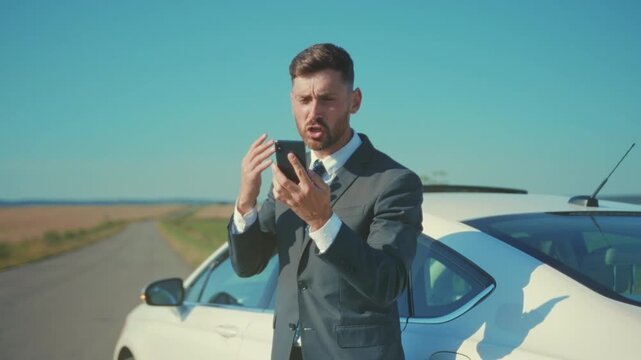 Business professional in distress requests aid, Man in business attire urgently contacts roadside assistance services