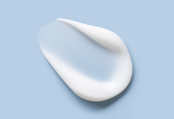 Close-up of cosmetic cream smear, smooth and shiny texture, blue background