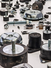 Metal and rubber parts are arranged on a table for sorting in a workshop during the day