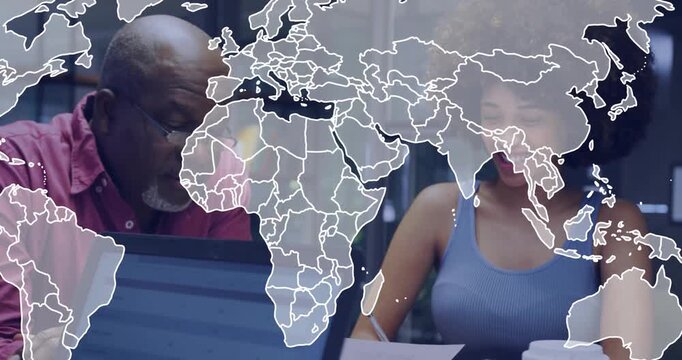 Senior exec and associate reviewing documents for strategy when faint world map overlay fading in